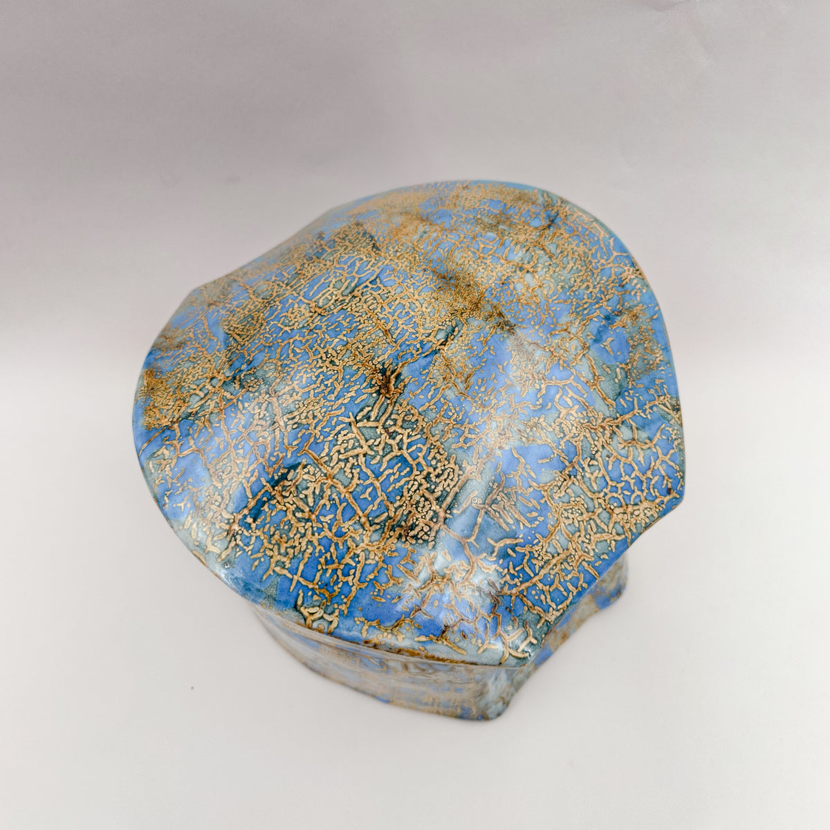 Caja con tapa azul y ocre — vista de la tapa.