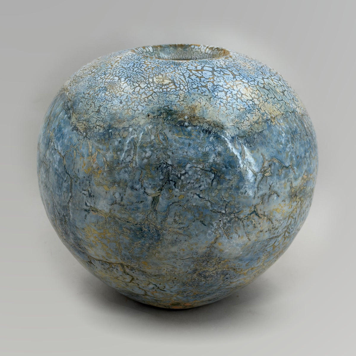 Veduta completa del vaso arrotondato con smalti azzurro pallido, crema e ocra.