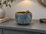 Ambientazione creata con IA : Chawan blu con reticolo ocra, su una console con una chiave.