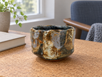 Ambientazione creata con IA : Chawan blu grigio con zone ocra, su un tavolo.