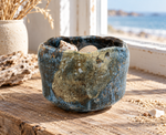 Ambientazione creata con IA : Chawan crema e blu con bordo ondulato, con conchiglie vicino al mare.