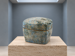 AI-generated setting : Blue grey box with an ochre network, on a travertine plinth.
