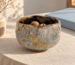 Ambientazione creata con IA : Chawan azzurro pallido con reticolo ocra, su un tavolo con perline di legno.